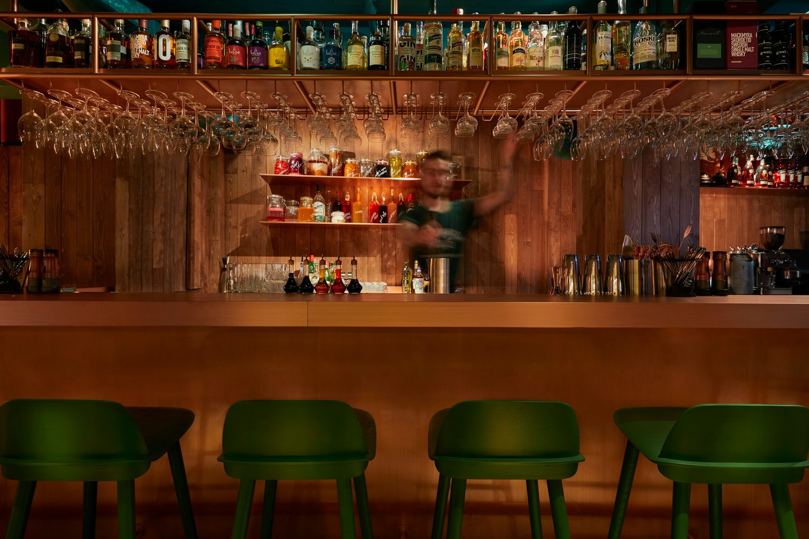 Balcão de bar em madeira com banquetas verdes